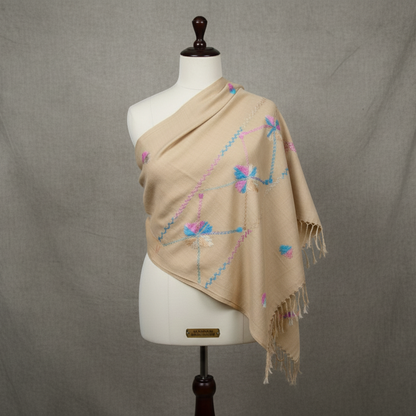Beige shawl with floral patterns draped over a mannequin against a gray background