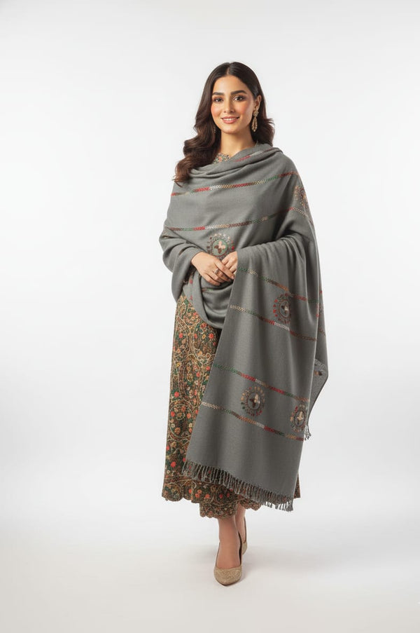 Woman wearing a gray patterned shawl over a floral dress on a white background